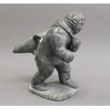 A large Inuit stone carving of a figure with a seal. 25.5 cm high.