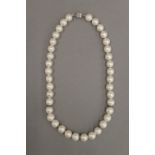 A pearl necklace with diamond set spacers. 43 cm long.
