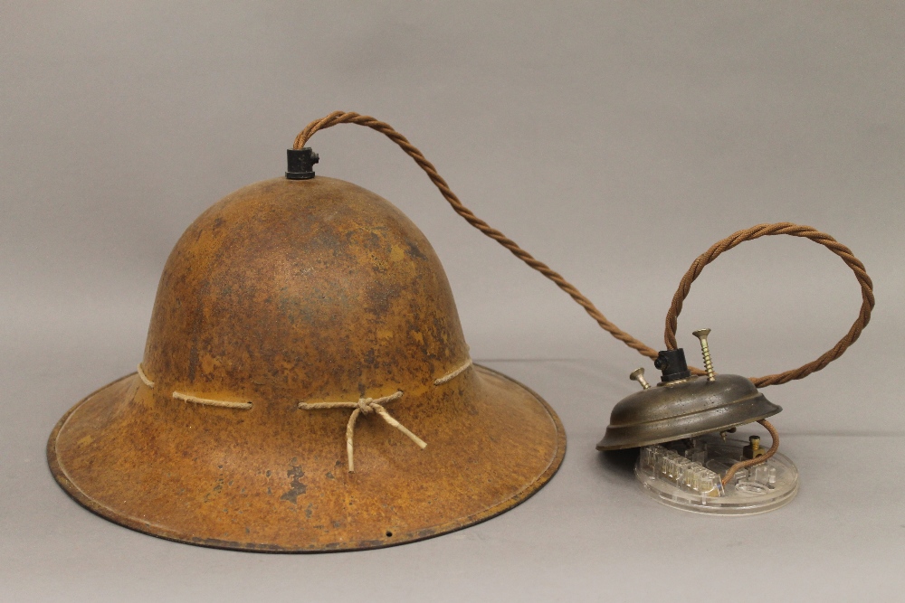 A Belgian military helmet, converted to a hanging lamp. 29 cm wide.