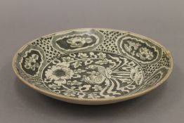 An antique Oriental pottery dish. 25.5 cm diameter.