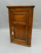 A Georgian oak hanging corner cupboard. 93 cm high.