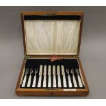 A set of six mother-of-pearl handled fruit knives and forks, with hallmarked silver blades,