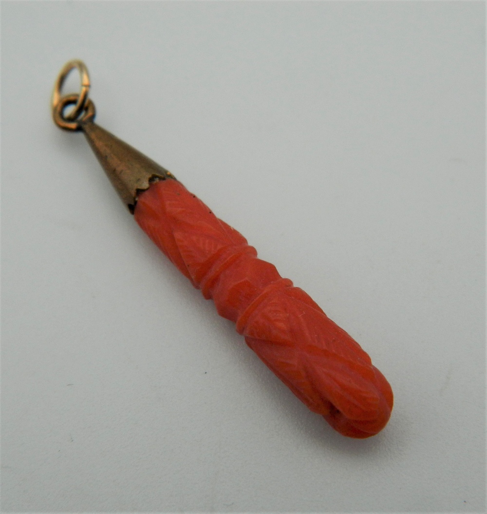 An Edwardian carved coral and gold pendant. 3 cm high.