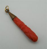 An Edwardian carved coral and gold pendant. 3 cm high.