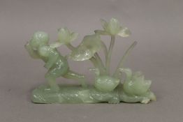 A jade carving of a boy with ducks.