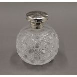 A silver topped cut glass scent bottle, hallmarked for Birmingham 1911. 11 cm high.