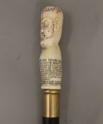 A walking stick with a carved bone phrenology head handle. 90.5 cm long.