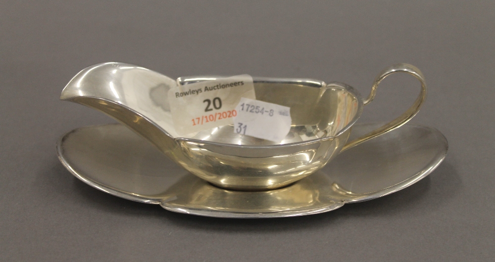 A small sterling silver sauce boat on stand. The stand 16 cm long. 137.9 grammes.