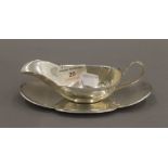 A small sterling silver sauce boat on stand. The stand 16 cm long. 137.9 grammes.