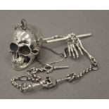 A white metal skull on chain. The skull 2 cm high.