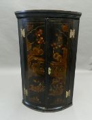 An 18th century chinoiserie lacquered hanging corner cupboard. 97 cm high.