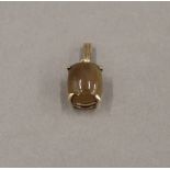 A 9 ct gold opal pendant. 1.5 cm high. 1.5 grammes total weight.