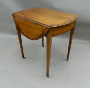 A 19th century oval crossbanded mahogany Pembroke table. 75 cm long.