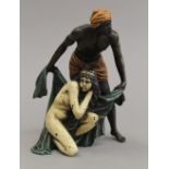 A cold painted bronze model of an Arab and nude. 14 cm high.