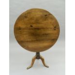A Georgian oak tilt-top tripod table. 82 cm diameter.