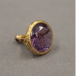 A 9 ct gold and amethyst fob. 2 cm high.