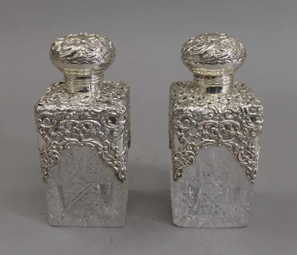 A pair of silver topped cut glass scent bottles. 14.5 cm high.