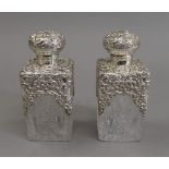 A pair of silver topped cut glass scent bottles. 14.5 cm high.