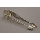 A pair of unmarked silver filigree sugar nips, possibly Maltese. 14 cm long. 30 grammes.