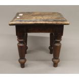 A 19th century elm stool. 34 cm high.