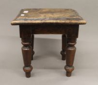 A 19th century elm stool. 34 cm high.