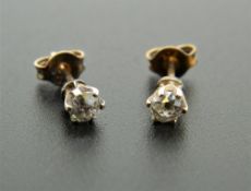 A pair of 9 ct gold diamond ear studs. Each 4 mm diameter.