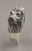 A silver whistle formed as a dog's head. 3.5 cm high.