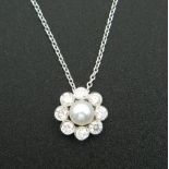 An 18 ct white gold diamond and pearl pendant, on an 18 ct white gold chain.