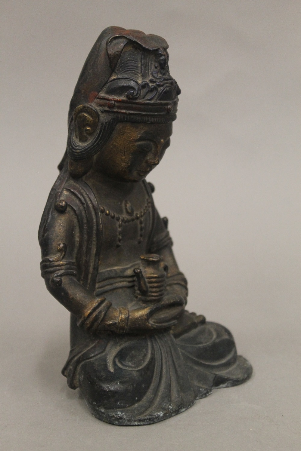 A seated bronze deity holding a teapot. 18 cm high. - Bild 2 aus 4