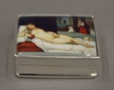 A silver pill box depicting a nude. 3 cm wide.