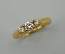 A vintage 18 ct gold diamond trilogy ring. Centre stone approximately 0.20 carats. Ring size K/L.