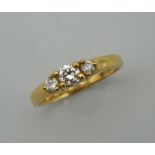 A vintage 18 ct gold diamond trilogy ring. Centre stone approximately 0.20 carats. Ring size K/L.