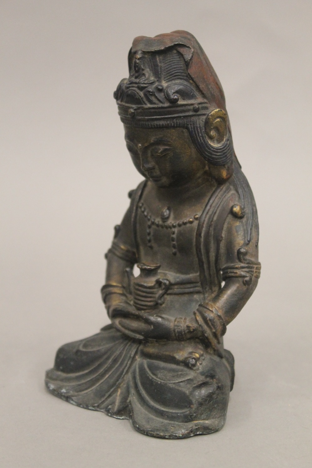 A seated bronze deity holding a teapot. 18 cm high. - Bild 4 aus 4