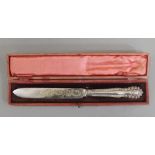 A cased silver handled cake knife. 30 cm long.