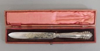 A cased silver handled cake knife. 30 cm long.