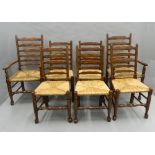 A set of eight rush seated ladder back chairs. The carvers 57.5 cm wide.