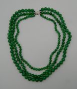 An 18 ct white gold jade and diamond necklace. Approximately 54 cm long.