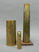 Three vintage artillery shells, one mounted on an oak base. The latter 30 cm high.