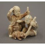 A late 19th/early 20th century Japanese carved ivory netsuke of two boys playing with a rabbit. 3.