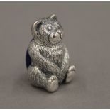 A silver pin cushion formed as a teddy bear