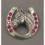 A sterling silver horse's head brooch. 3 cm wide.