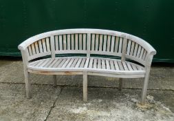A curved wooden garden bench