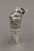 A silver whistle formed as a rabbit's head. 4 cm high.