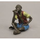 A cold painted bronze model of a boy smoking a pipe. 6 cm high.