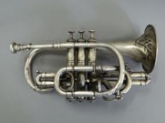 A silver plated cornet. 32 cm long.