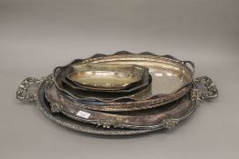 A quantity of silver plated trays. The largest 65 cm long.