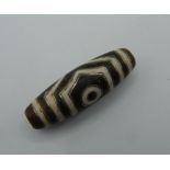 A Tibetan gold inlaid dzi bead. 3.5 cm long.