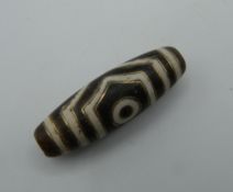 A Tibetan gold inlaid dzi bead. 3.5 cm long.