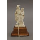 An early 20th century Indian ivory group, on stand. 13 cm high.