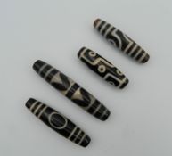 Four agate dzi beads. The largest 7.5 cm long.